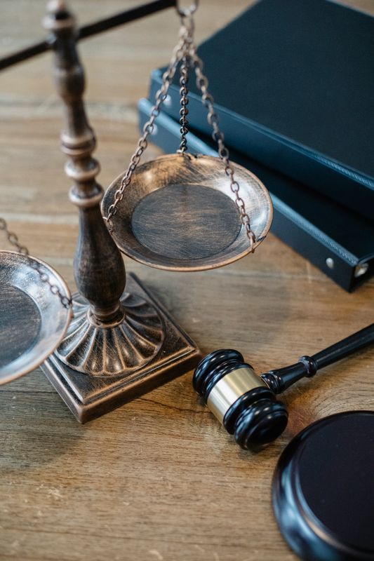 Терези правосуддя й молоток судді на дерев'яній поверхні